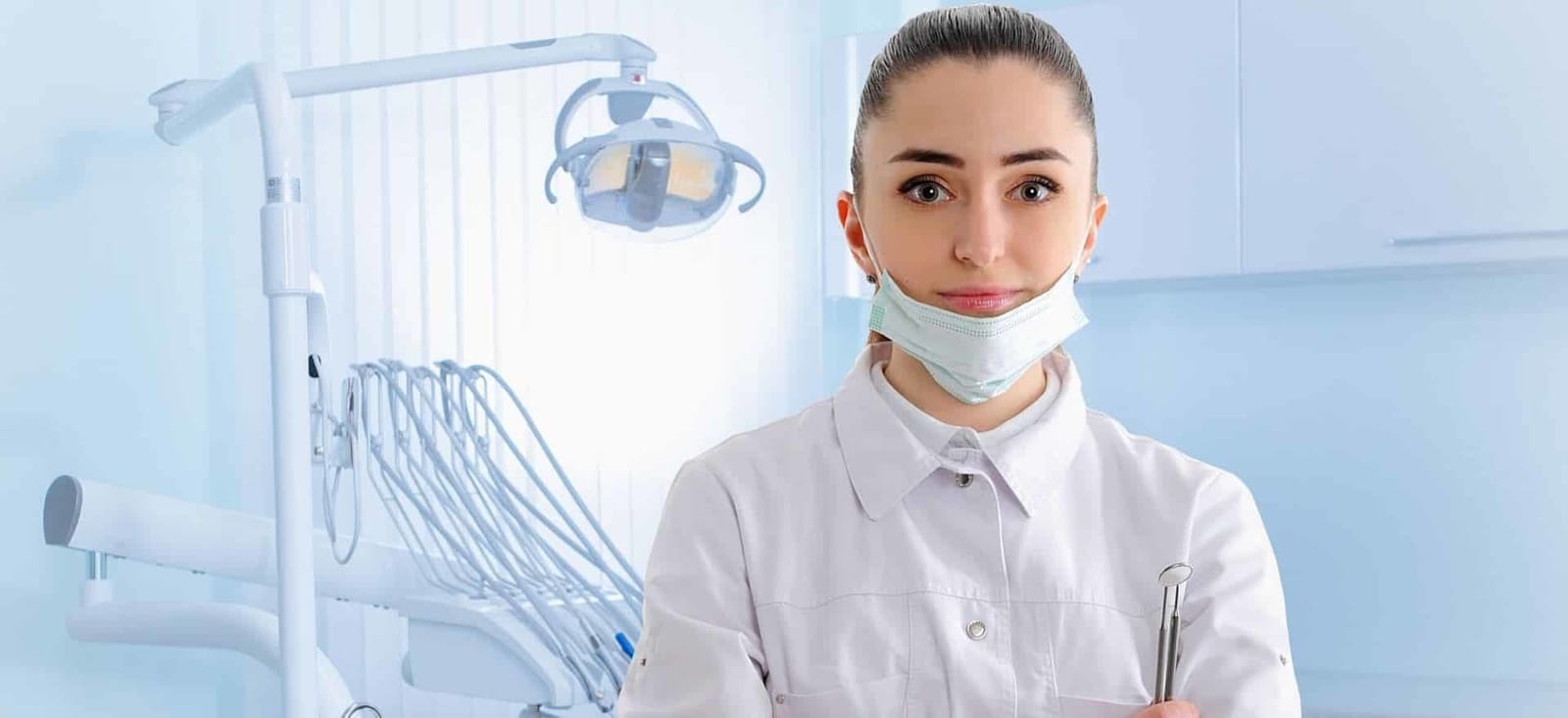 Osoba w odzieży medycznej przy sprzęcie dentystycznym