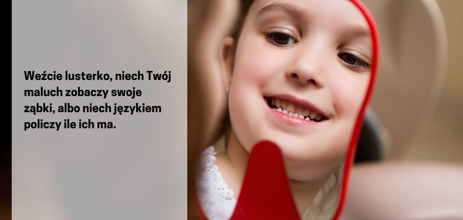 Dziecko ogląda zęby w ręcznym lusterku