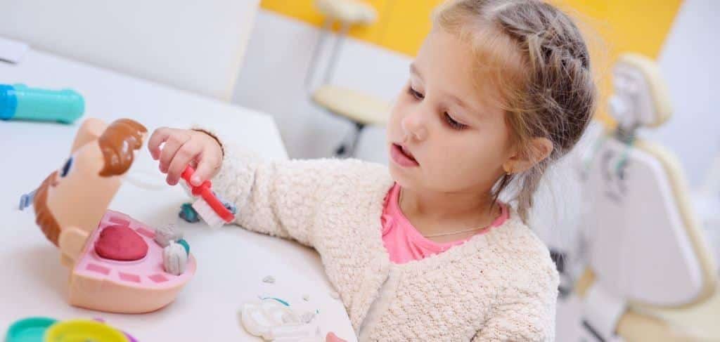 Dziecko bawiące się modelem ust i szczoteczką