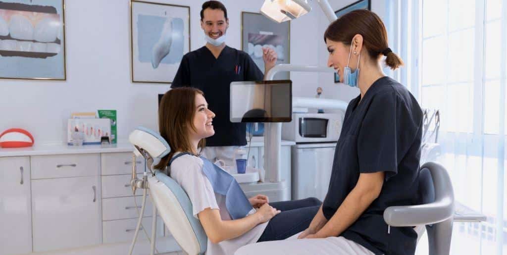 Pacjentka rozmawiająca z zespołem stomatologicznym obok fotela