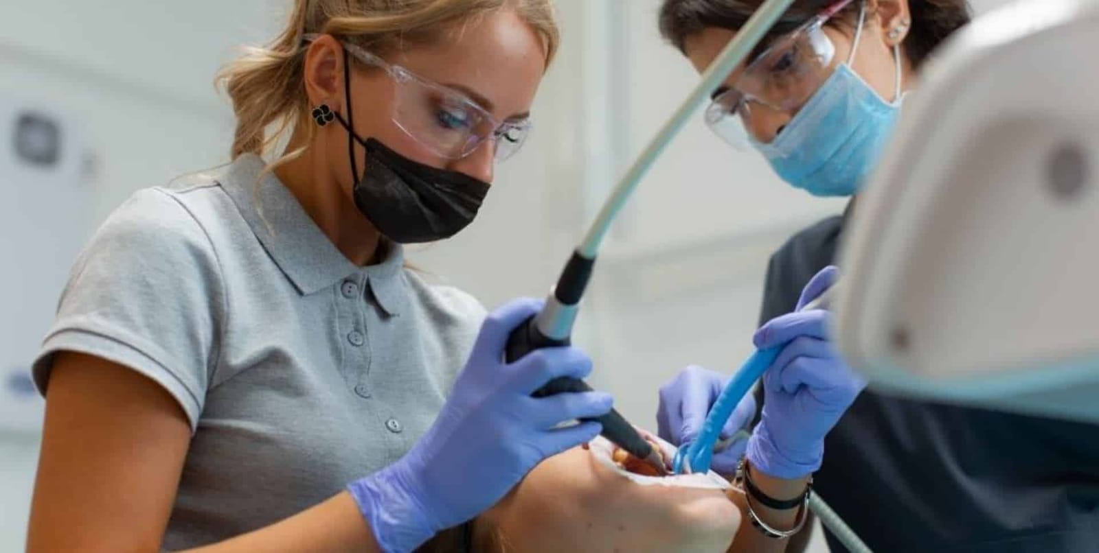 Dwie osoby z zespołu stomatologicznego podczas zabiegu