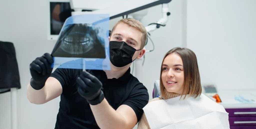 Dentysta pokazuje pacjentce panoramiczne zdjęcie RTG
