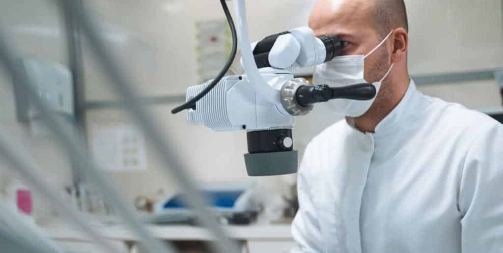 Dentysta patrzący przez mikroskop stomatologiczny