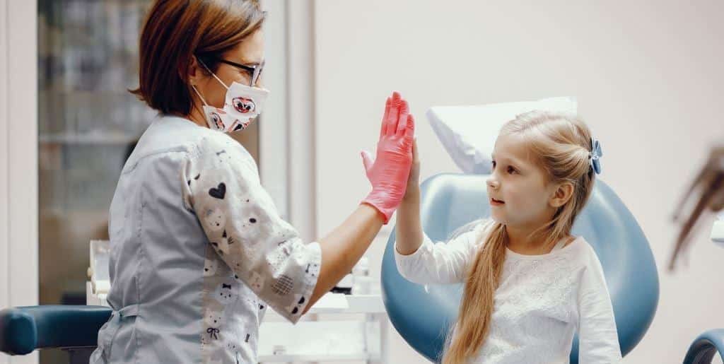 Dziecko i osoba z zespołu przybijające piątkę