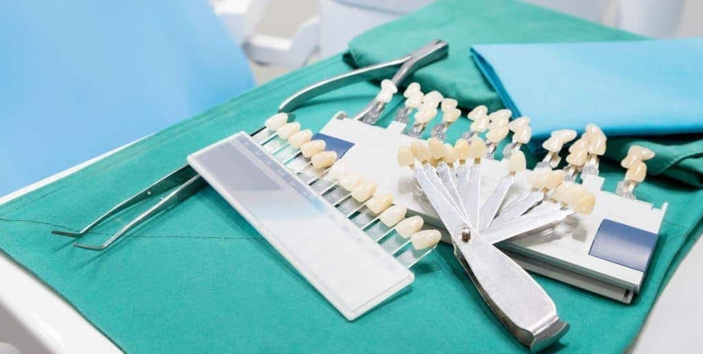 Narzędzia stomatologiczne i kolorniki zębów na tacy