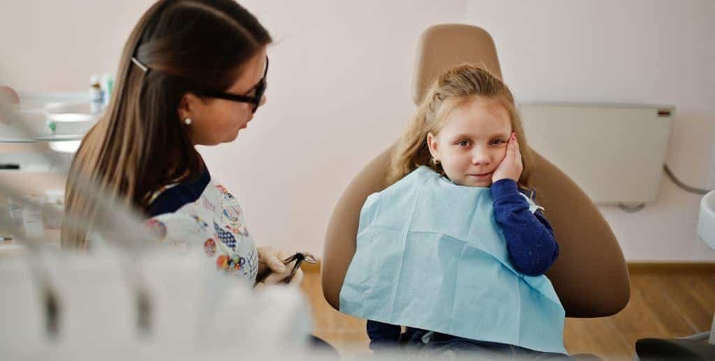 Dentystka rozmawia z dzieckiem na fotelu