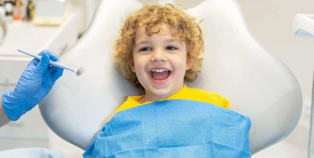 Dziecko uśmiecha się w fotelu dentystycznym