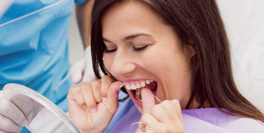 Czyszczenie przestrzeni między zębami nicią dentystyczną