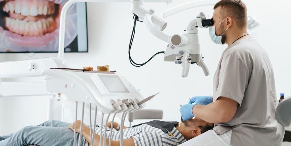 Dentysta pracuje z mikroskopem stomatologicznym