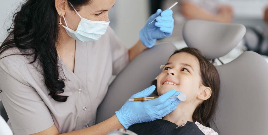 Dentystka bada zęby dziecka