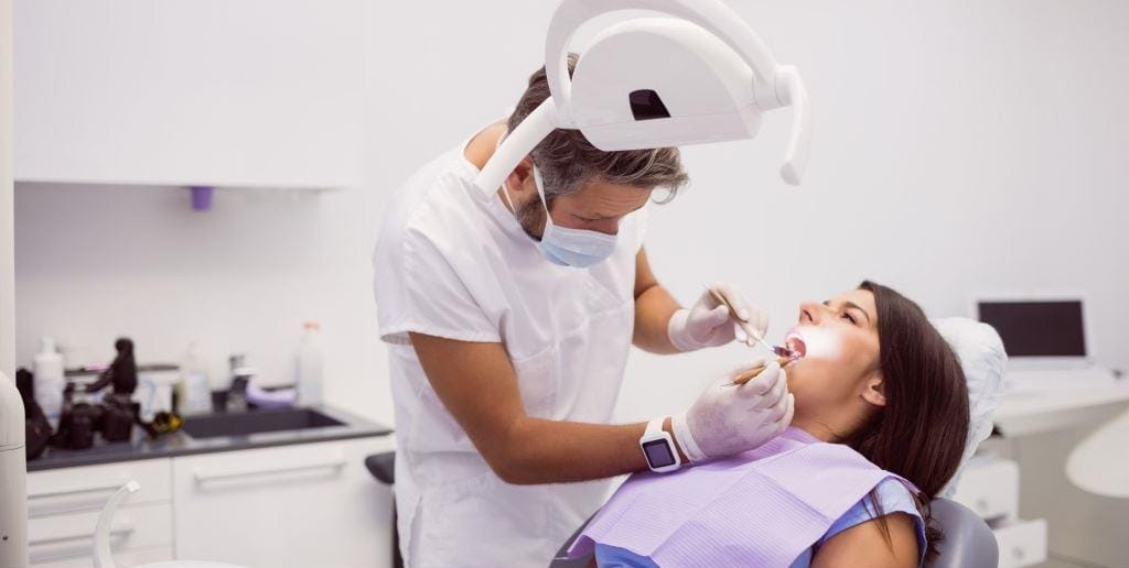 Dentystka lecząca pacjentkę na fotelu