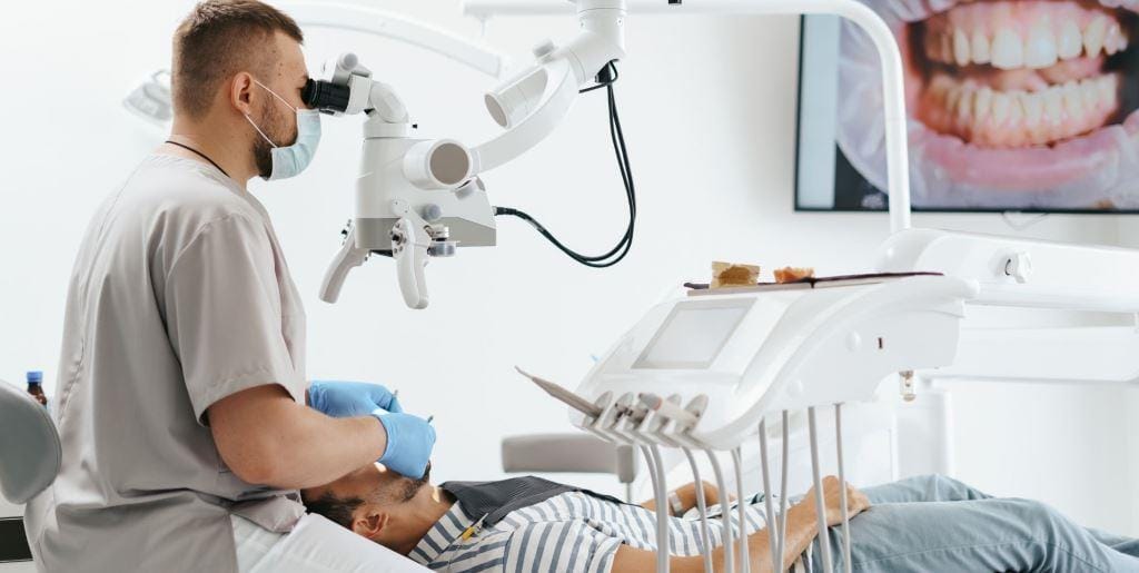 Dentysta używający mikroskopu podczas leczenia