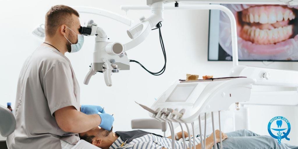 Dentysta korzystający z mikroskopu podczas leczenia