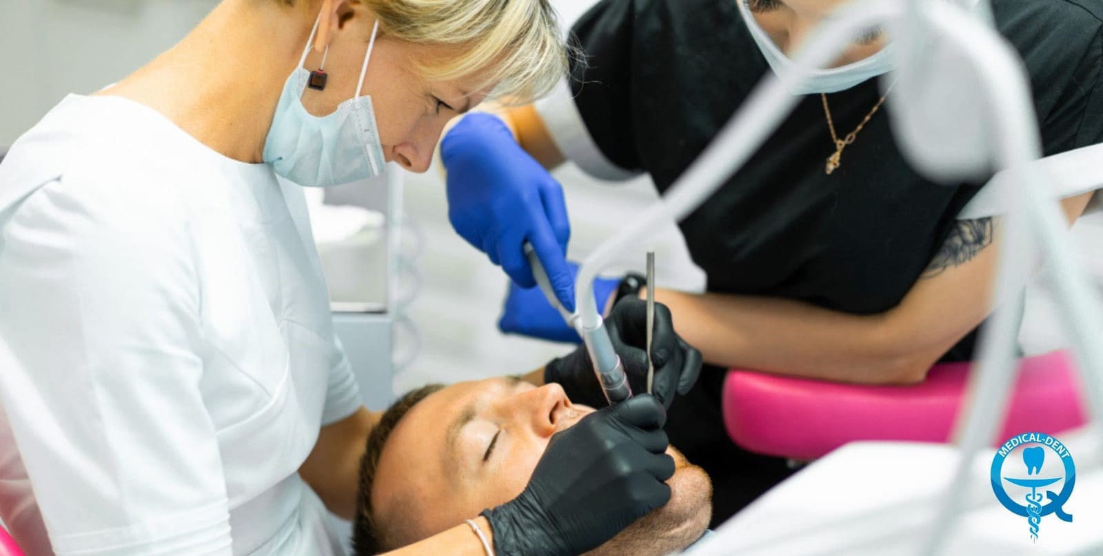 Dentysta i asysta podczas leczenia pacjenta na fotelu