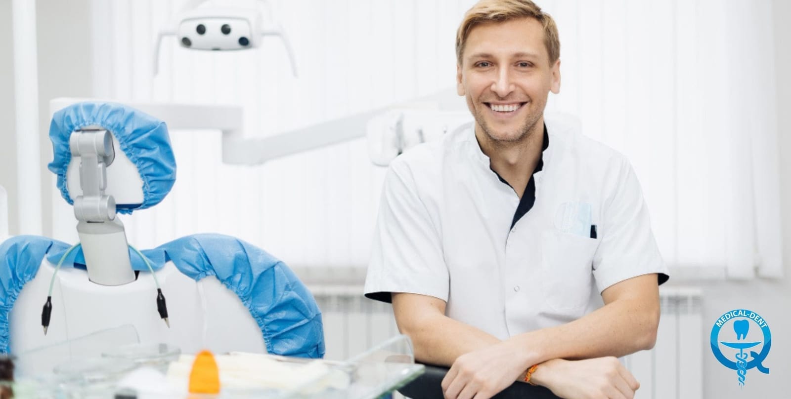 Uśmiechnięty dentysta obok fotela stomatologicznego