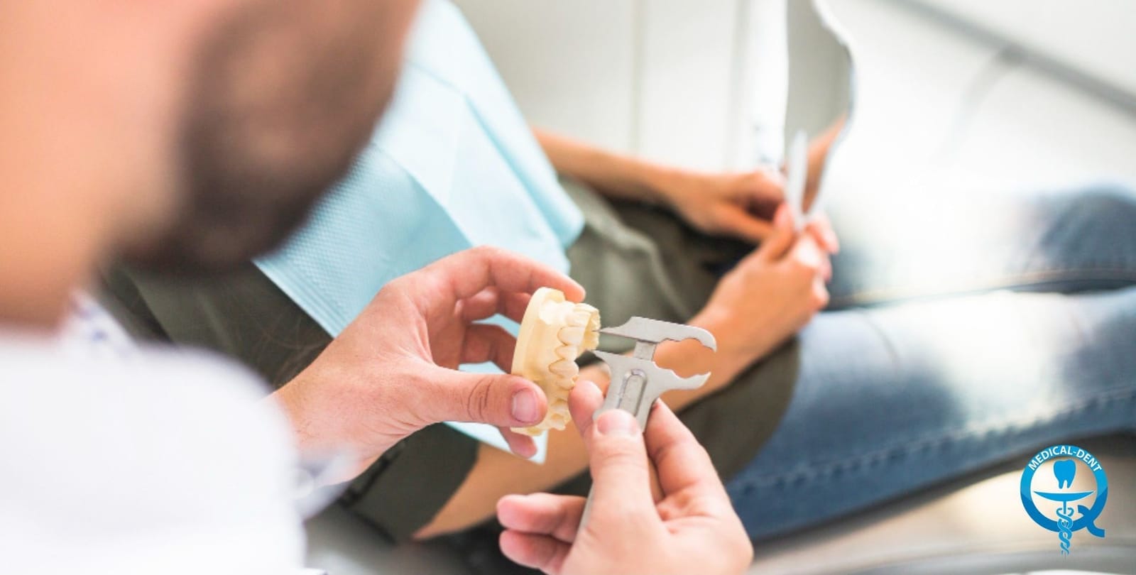 Dentysta pokazujący pacjentowi protezę częściową