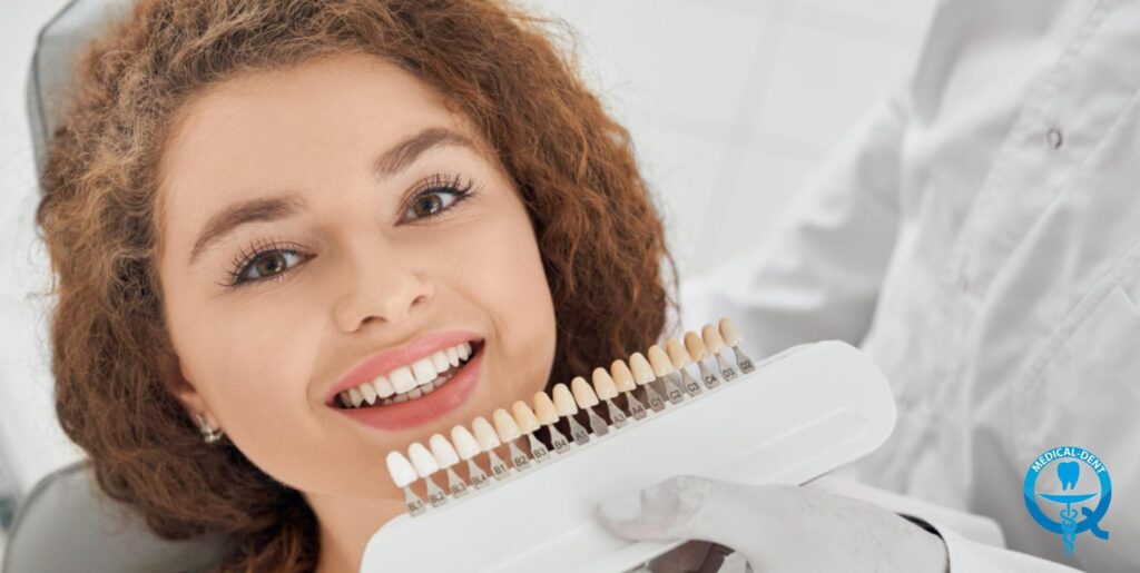 'Patient in the dental surgery during tooth shade matching. A tooth colour palette is exemplified next to her smile. The logo of the dental clinic is visible in the lower right corner."