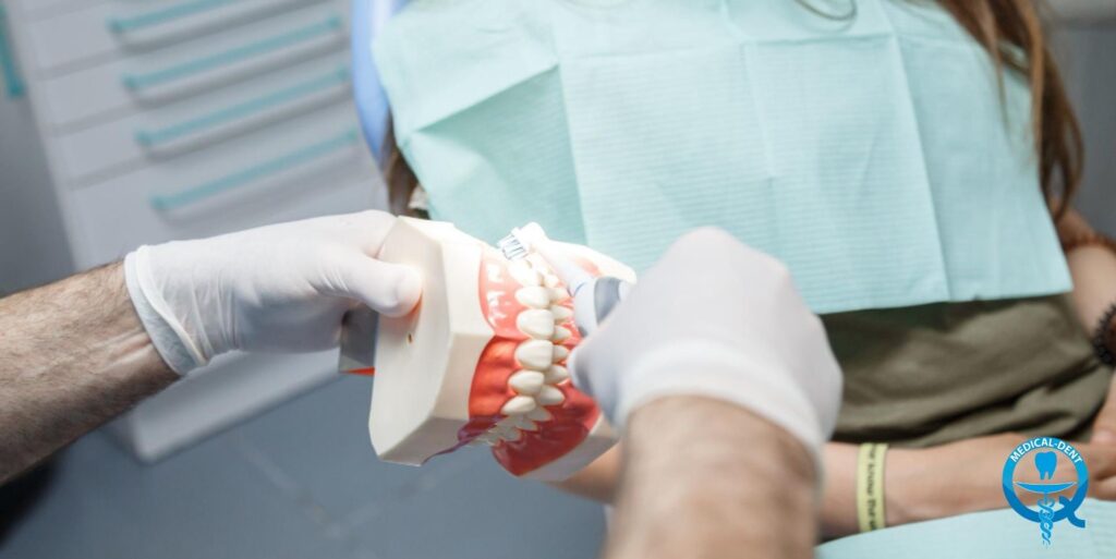 Dentysta w białych rękawiczkach trzymający model szczęki z zębami i przezroczystą szyną ortodontyczną do leczenia bruksizmu