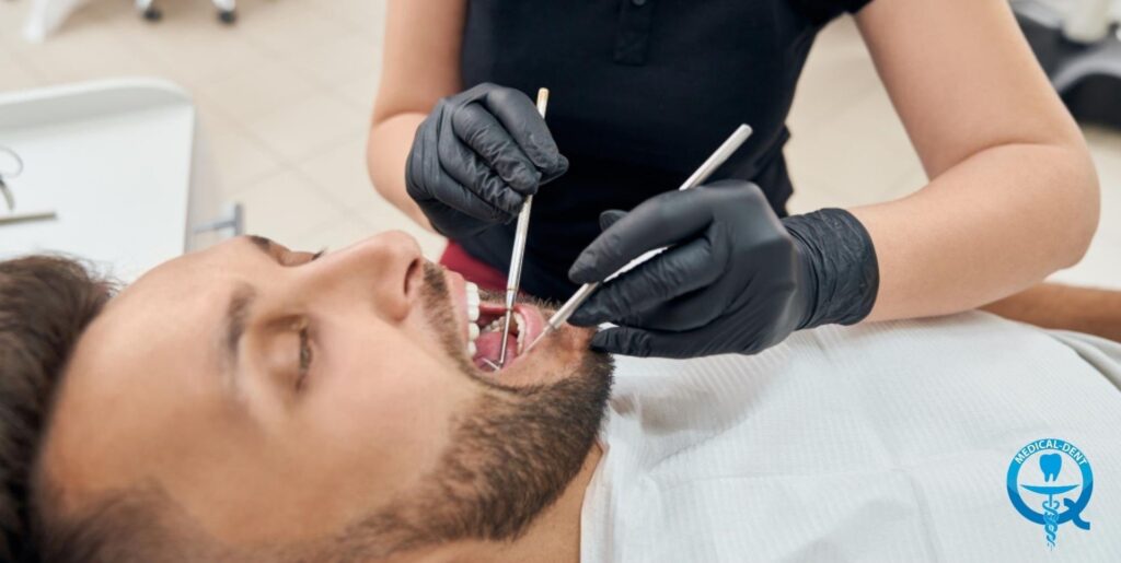 A dentist wearing black gloves treats periodontitis in a patient lying in a dental chair, using dental instruments.